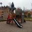 Tintagel playground castle avec toboggan et structure d’escalade dans une aire de jeux résidentielle.'
